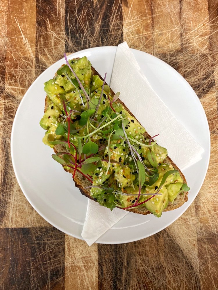 Avocado toast with smashed avocado, olive oil, salt, pepper, and local microgreens
